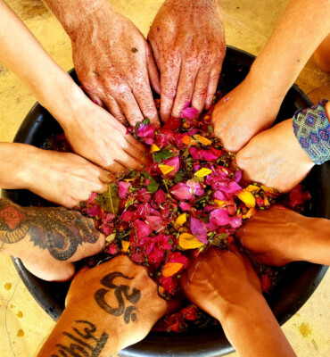 Hands holding flower petals in a ceremony bowl